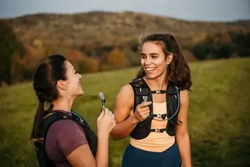 Two women wearing hydration vests